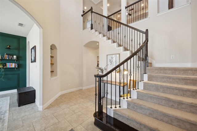 4600 Periwinkle Dr, Mansfield, TX 76063 - stairs with built in shelves, baseboards, arched walkways, a towering ceiling, and tile patterned flooring