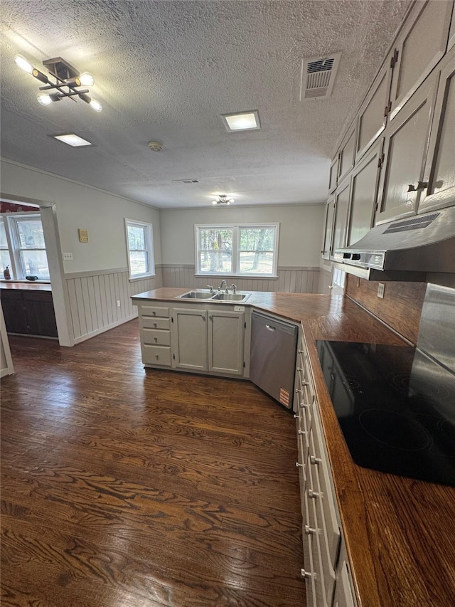 kitchen featuring a peninsula, visible vents, a wainscoted wall, and dishwasher
