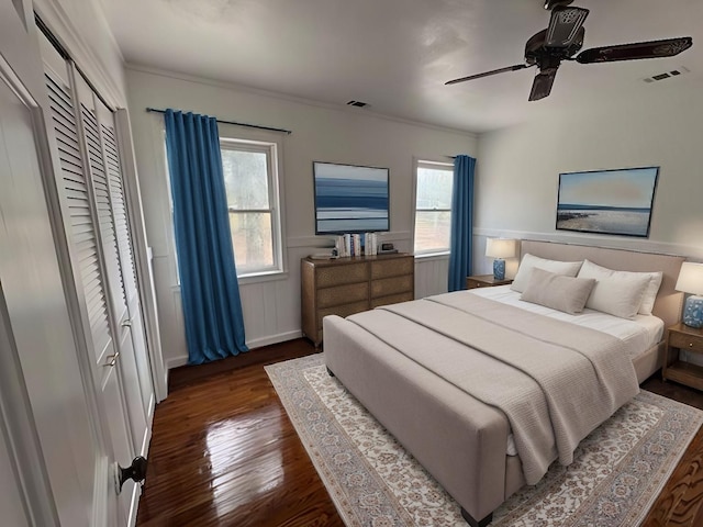 bedroom with visible vents, a ceiling fan, wainscoting, and wood finished floors