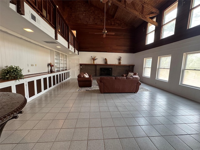living room featuring ceiling fan, a fireplace, wood walls, wooden ceiling, and high vaulted ceiling