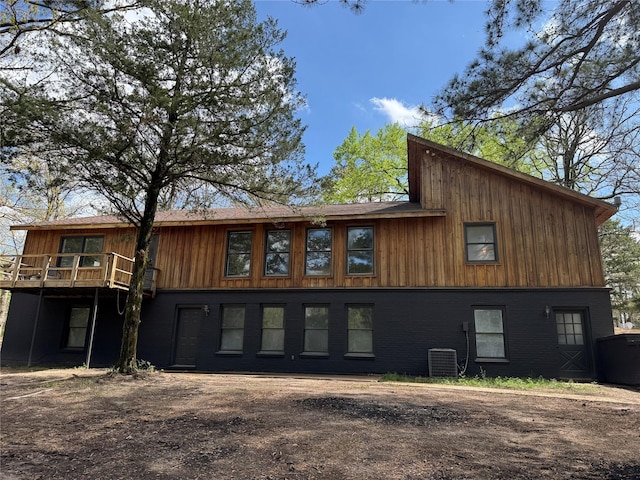 rear view of property featuring a wooden deck and central AC
