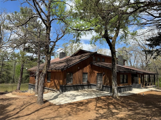 rear view of house with a chimney and a patio area