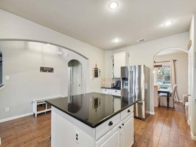 4013 Hollow Lake Rd, Fort Worth, TX 76262 - kitchen with high end fridge, arched walkways, dark countertops, white cabinets, and light wood-style flooring