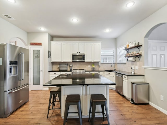 4013 Hollow Lake Rd, Fort Worth, TX 76262 - kitchen with appliances with stainless steel finishes, a sink, dark countertops, a breakfast bar area, and recessed lighting