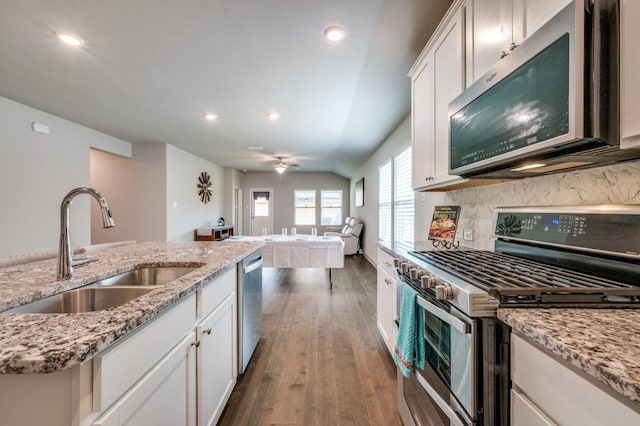 kitchen featuring tasteful backsplash, a sink, dark wood-style floors, stainless steel appliances, and white cabinetry