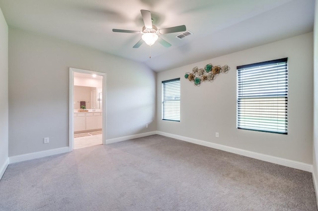 carpeted spare room featuring baseboards, a ceiling fan, and visible vents