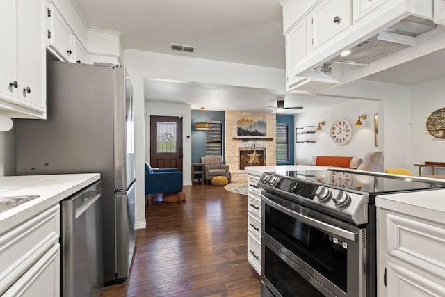 kitchen featuring dark wood-style floors, open floor plan, under cabinet range hood, stainless steel appliances, and visible vents
