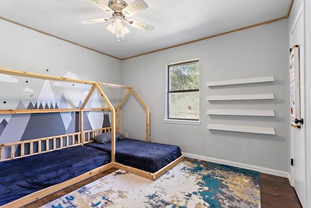 unfurnished bedroom with baseboards, crown molding, wood finished floors, and ceiling fan