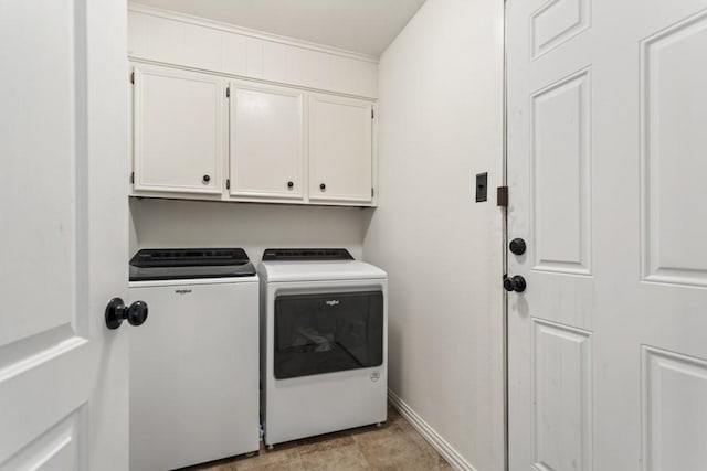 laundry room featuring washing machine and clothes dryer, cabinet space, and baseboards