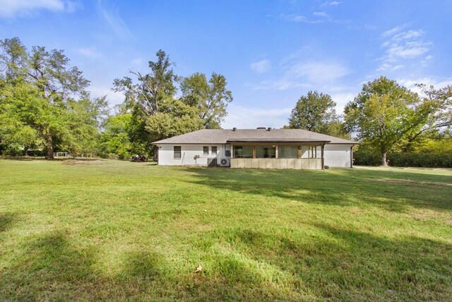 rear view of property with a lawn