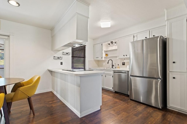 kitchen with light countertops, open shelves, a sink, a peninsula, and appliances with stainless steel finishes