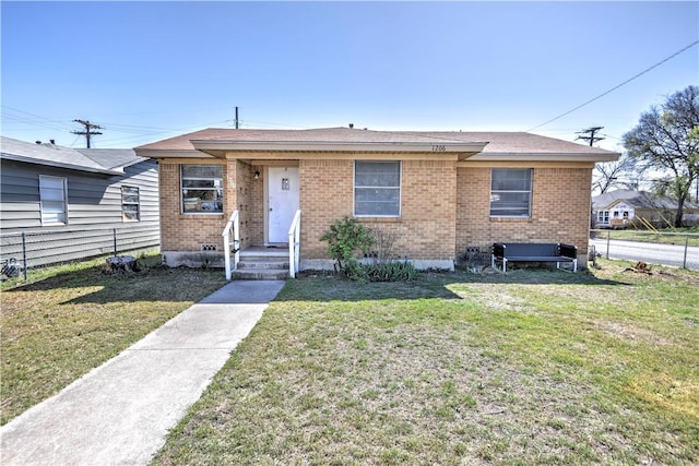 bungalow-style house with brick siding, fence, and a front lawn