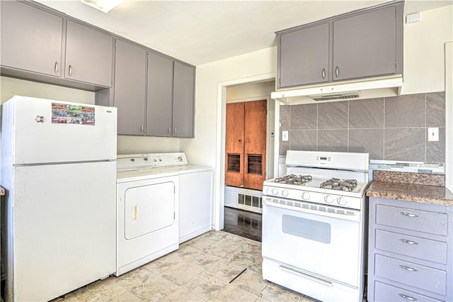 kitchen with gray cabinets, washing machine and dryer, under cabinet range hood, white appliances, and visible vents