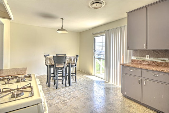 kitchen featuring gray cabinetry, visible vents, decorative backsplash, and gas range gas stove
