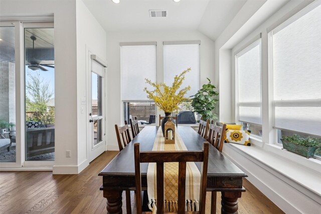 dining area featuring wood finished floors, baseboards, lofted ceiling, and visible vents