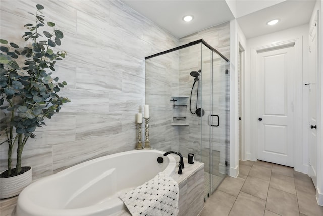 bathroom featuring a bath, tile walls, a stall shower, and tile patterned floors