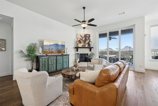 living room featuring hardwood / wood-style floors, ceiling fan, visible vents, and a healthy amount of sunlight