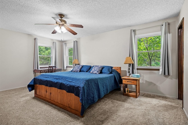 carpeted bedroom with multiple windows, a textured ceiling, and ceiling fan