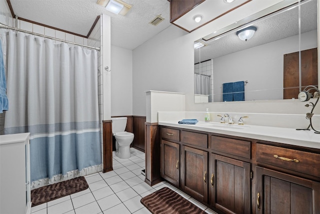 full bathroom with toilet, visible vents, a textured ceiling, and a wainscoted wall