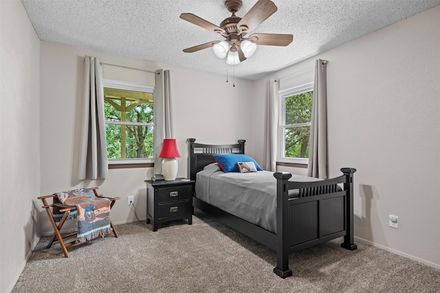 bedroom with carpet floors, baseboards, a ceiling fan, and a textured ceiling