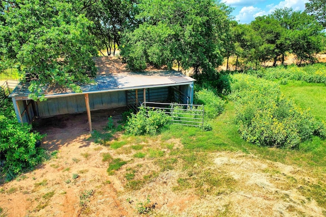exterior space with an outdoor structure, a detached carport, and dirt driveway