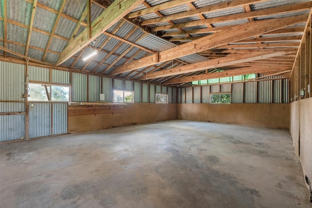 miscellaneous room featuring a garage, vaulted ceiling, and concrete flooring