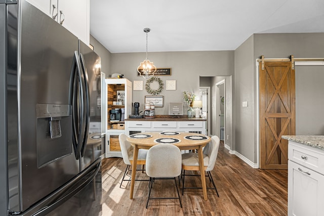 123 Oak Springs Loop, Mabank, TX 75147 - dining area with a barn door, dark wood-style floors, baseboards, and a chandelier