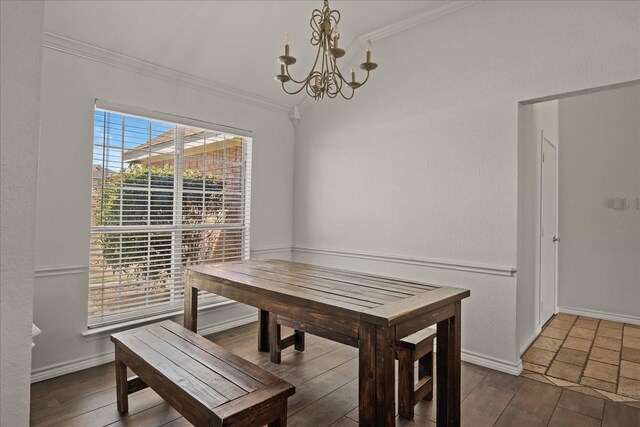 dining area featuring crown molding, baseboards, wood finished floors, lofted ceiling, and an inviting chandelier