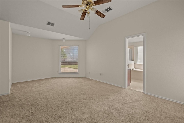 carpeted empty room with vaulted ceiling, baseboards, ceiling fan, and visible vents