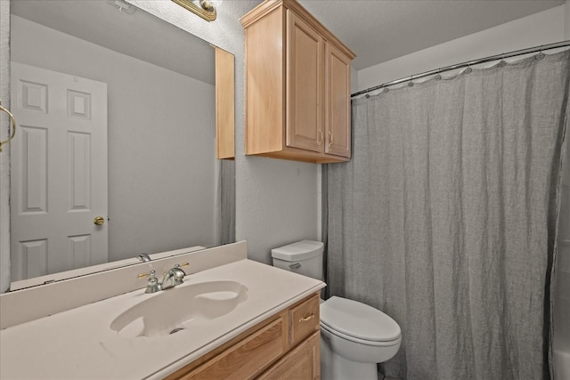 bathroom featuring a textured wall, toilet, a shower with shower curtain, and vanity