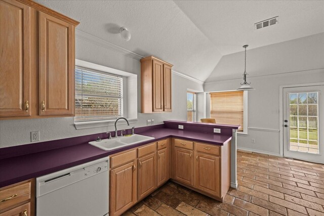 kitchen with visible vents, a peninsula, dark countertops, a sink, and white dishwasher