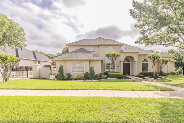 mediterranean / spanish home with a gate, fence, a front lawn, and stucco siding