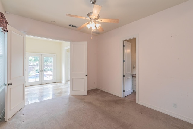 empty room with light colored carpet, ceiling fan, baseboards, visible vents, and french doors