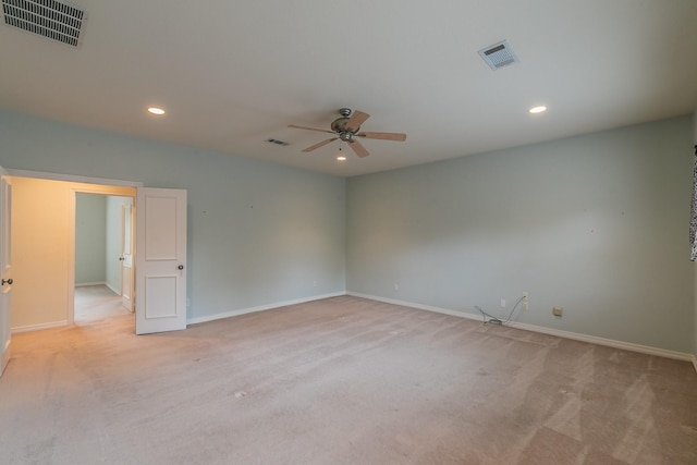 spare room featuring visible vents, ceiling fan, and light carpet