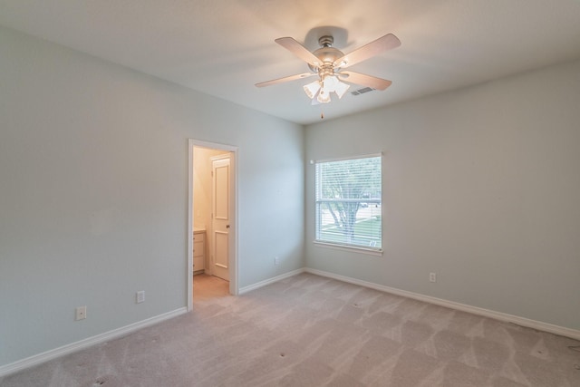 empty room featuring baseboards, a ceiling fan, and light carpet