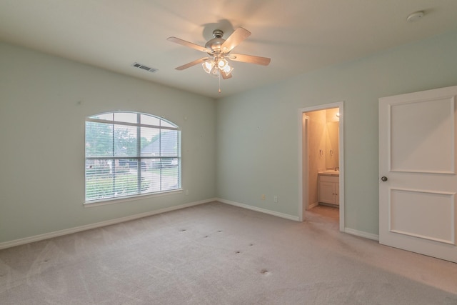 unfurnished bedroom with visible vents, ensuite bath, light carpet, and baseboards