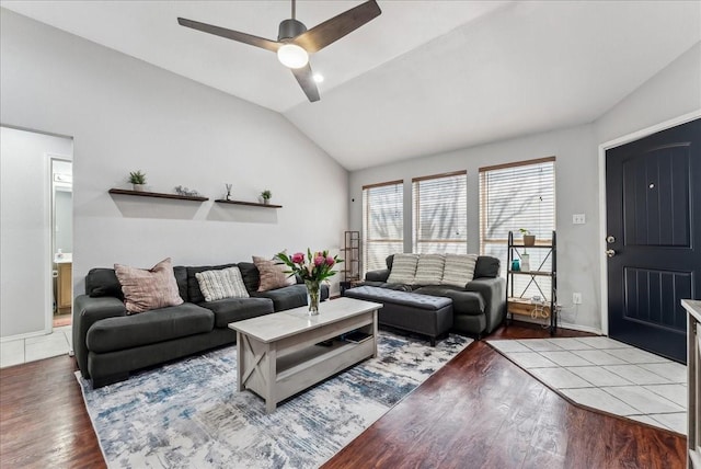 living area with baseboards, vaulted ceiling, wood finished floors, and a ceiling fan