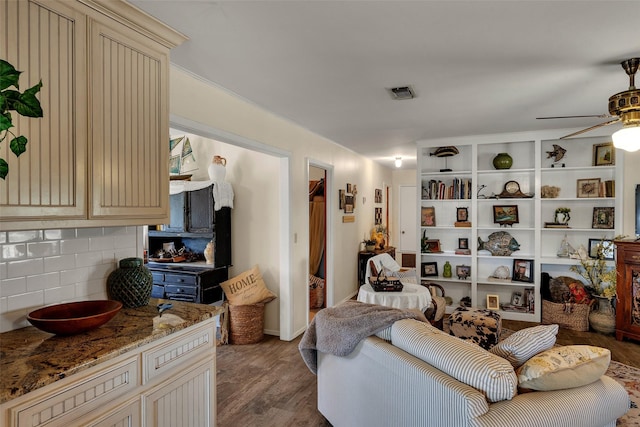 living room featuring visible vents, ceiling fan, and wood finished floors