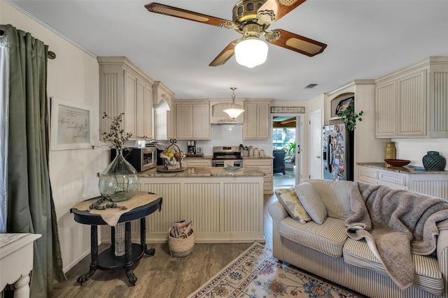 kitchen with cream cabinets, a ceiling fan, stainless steel appliances, and a peninsula