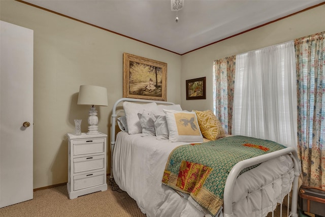 bedroom with baseboards, crown molding, and light carpet
