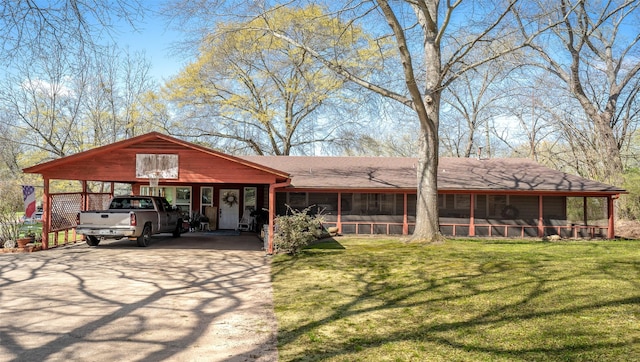 view of front of home featuring a sunroom, a front lawn, concrete driveway, and a carport