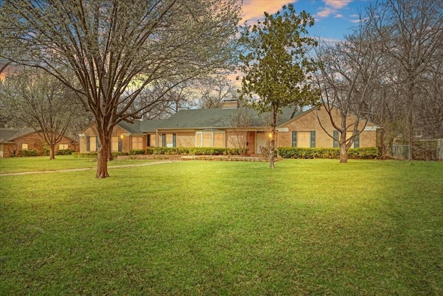 view of front of house featuring a yard, a chimney, and fence