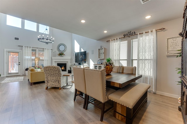 dining space featuring light wood finished floors, an inviting chandelier, visible vents, and a wealth of natural light
