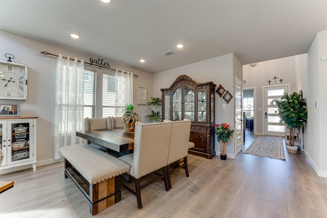 dining area with baseboards, light wood finished floors, visible vents, and plenty of natural light