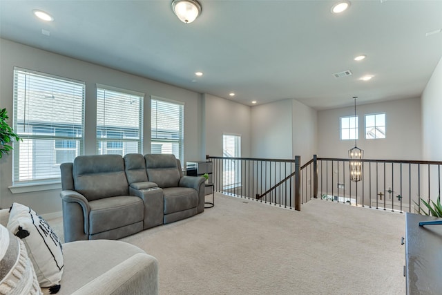 carpeted living area featuring visible vents, recessed lighting, and a notable chandelier