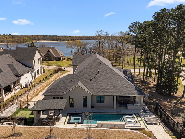 2432 Bellview Cir, Tyler, TX 75709 - view of swimming pool featuring a fenced backyard, a patio area, a pool with connected hot tub, and a water view