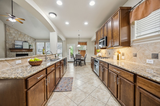 9721 Stripling Dr, Fort Worth, TX 76244 - kitchen featuring appliances with stainless steel finishes, a sink, tasteful backsplash, light stone counters, and ceiling fan