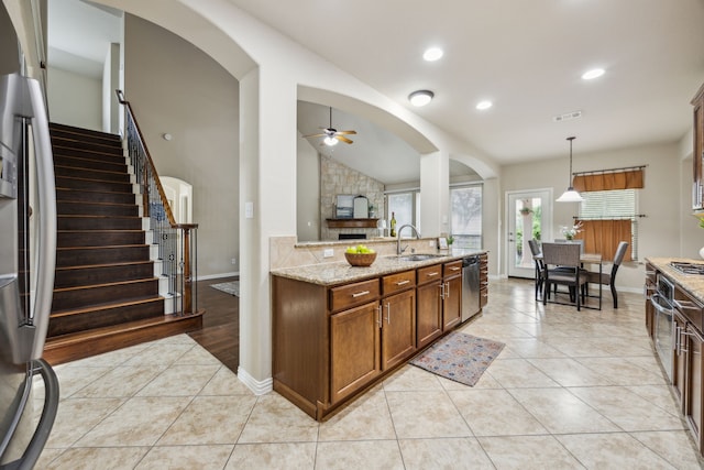 9721 Stripling Dr, Fort Worth, TX 76244 - kitchen featuring a sink, stainless steel appliances, light tile patterned floors, arched walkways, and lofted ceiling