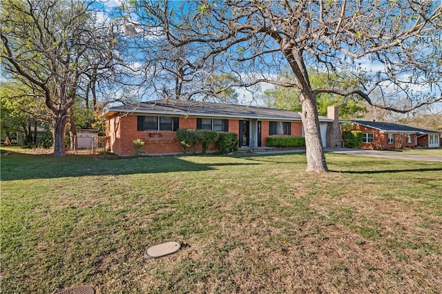 single story home with driveway, brick siding, a front lawn, and an attached garage