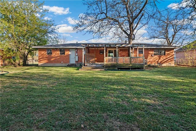 rear view of house featuring a lawn and brick siding